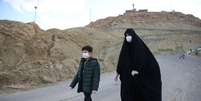Com máscara e luvas de proteção contra novo coronavírus, mulher e seu filho caminham por estrada do Irã
24/03/2020
WANA (West Asia News Agency) via REUTERS   Foto: Reuters