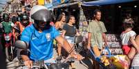 Pessoas caminham próximas umas às outras na favela Paraisópolis, em São Paulo, apesar da epidemia de covid-19  Foto: DW / Deutsche Welle