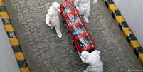 Doente é transportado por agente de saúde em Seul  Foto: DW / Deutsche Welle