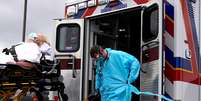 Com equipamentos protetores, paramédicos transportam paciente com suspeita de coronavírus em Shawnee, Oklahoma (EUA) 
02/04/2020
REUTERS/Nick Oxford  Foto: Reuters