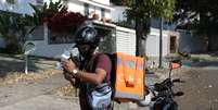 Entregador usa telefone celular para contactar cliente em Caracas
14/04/2020 REUTERS/Manaure Quintero  Foto: Reuters