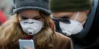 Com máscara de proteção contra coronavírus, mulher utiliza celular em Kiev, Ucrânia 
17/03/2020
REUTERS/Valentyn Ogirenko  Foto: Reuters