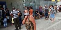 Mulher usa máscara enquanto outras pessoas aguardam em fila de banco no Rio de Janeiro
15/04/2020 REUTERS/Ricardo Moraes  Foto: Reuters