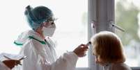 Uma enfermeira, com equipamento de proteção, checa a temperatura de uma paciente na França. 30/04/2020. REUTERS/Stephane Mahe. 
  Foto: Reuters