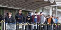 P&uacute;blico segue as diretrizes de distanciamento social enquanto fazem fila na frente &agrave; uma loja em Leicester, enquanto o Reino Unido continua em confinamento para ajudar a conter a propaga&ccedil;&atilde;o do coronav&iacute;rus.  Foto: Reuters
