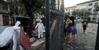 Funcionários do serviço funerário, usando roupas de proteção, recolhem o corpo de uma pessoa que morreu por problemas respiratórios em meio à pandemia do coronavírus, no Rio de Janeiro. 17/5/2020. REUTERS/Ricardo Moraes  Foto: Reuters