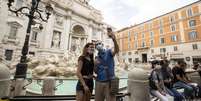 Amigos tiram foto em frente à Fontana di Trevi, em Roma, após reabertura  Foto: ANSA / Ansa - Brasil