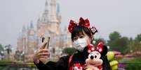 Visitante de parque da Disney tira selfie usando m&aacute;scara de prote&ccedil;&atilde;o. 11/5/2020. REUTERS/Aly Song       Foto: Reuters