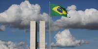 Bandeira do Brasil hasteada na Rua das Bandeiras, em Brasília, tendo, ao fundo, o Congresso Nacional  Foto: Gabriela Biló / Estadão Conteúdo
