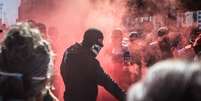 Um grupo de manifestantes pró-democracia, vestidos de pretos e usando máscaras, realiza um ato em frente ao Museu de Arte de São Paulo (Masp)  Foto: TABA BENEDICTO / Estadão Conteúdo
