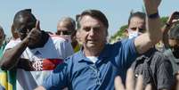 Sem máscara protetora, o presidente da República, Jair Bolsonaro, acena e cumprimenta apoiadores que participavam de um ato diante do Palácio do Planalto, na Praça dos Três Poderes, em Brasília, neste domingo, 31 de maio de 2020  Foto: EDU ANDRADE/FATOPRESS / Estadão Conteúdo