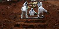 Coveiros com trajes de proteção enterram homem morto pela Covid-19 em cemintério em São Paulo
04/06/2020
REUTERS/Amanda Perobelli  Foto: Reuters