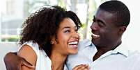 Mulher e homem se abra&ccedil;ando sentados, ambos riem  Foto: Shutterstock / Alto Astral