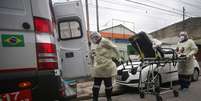 Os enfermeiros do SAMU transportam um paciente de uma unidade básica de saúde para um hospital durante o surto de coronavírus, em Santo André  Foto: Rahel Patrasso / Reuters