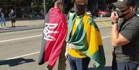 Bandeira vermelho e negra com brasão ucraniano é considerada um símbolo ligado ao neonazismo  Foto: Reprodução/Twitter / BBC News Brasil