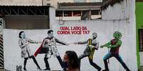 Mulher passa por grafite pintado em muro em São Paulo
10/06/2020
REUTERS/Amanda Perobelli  Foto: Reuters