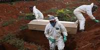 Coveiros com trajes de prote&ccedil;&atilde;o fazem o sepultamento de uma pessoa que morreu infectada pelo novo coronav&iacute;rus, no cemit&eacute;rio de Vila Formosa, em S&atilde;o Paulo
22/05/2020
REUTERS/Amanda Perobelli  Foto: Reuters