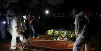 Coveiros com trajes de proteção enterram homem que morreu devido à Covid-19, no cemitério de Vila Formosa, em São Paulo
19/06/2020
REUTERS/Amanda Perobelli  Foto: Reuters