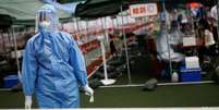 Funcionário de saúde em centro de testagem de covid-19 em Pequim  Foto: DW / Deutsche Welle