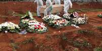 Coveiros com traje de proteção carregam caixão de mulher que morreu infectada pelo novo coronavírus, no cemitério de Vila Formosa, em São Paulo
26/06/2020
REUTERS/Amanda Perobelli  Foto: Reuters