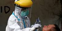 Profissional de saúde coleta amostra de servidor civil para teste de coronavírus
02/07/2020
REUTERS/Willy Kurniawan  Foto: Reuters
