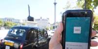 Táxi em Londres passa enquanto aplicativo do Uber é mostrado em smartphone em primeiro plano. 22/9/2017. REUTERS/Toby Melville  Foto: Reuters