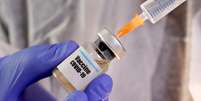 Pessoa manipula frasco com etiqueta nomeando vacina contra covid-19  Foto: Dado Ruvic / Reuters