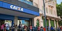 Pessoas fazem fila para coletar aux&iacute;lio emergencial em meio &agrave; pandemia de coronav&iacute;rus  Foto: Getty Images / BBC News Brasil