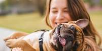 Cachorro brincando com uma mulher  Foto: Shutterstock / Alto Astral