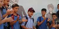 Abdel-Rahman Al-Shantti (ao centro, de boné), rapper de 11 anos de Gaza, é cercado por estudantes durante performance
16/08/2020 REUTERS/Mohammed Salem  Foto: Reuters