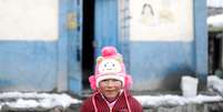 Criança posa para foto na entrada de sua escola em La Rinconada, no Peru
04/10/2019 REUTERS/Nacho Doce  Foto: Reuters