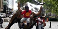 Crianças brincam em cima e estátua e touro localizada em frente à Bolsa de Valores de Nova York
19/08/2020 REUTERS/Carlo Allegri  Foto: Reuters