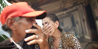 Os irmãos Rosalino e Miraceli de Oliveira tentam se proteger da fumaça nas proximidades de casa, perto de Porto Velho, em foto recente; milhões de pessoas são afetadas por níveis de poluição acima do recomendado na Amazônia, alerta relatório  Foto: REUTERS/Ueslei Marcelino / BBC News Brasil