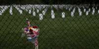 Flores são dispostas em grade de cemitério no Estado da Virginia, Estados Unidos. 27/05/2020. REUTERS/Carlos Barria. 

  Foto: Reuters