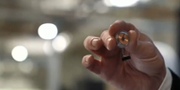 Elon Musk segura o chip desenvolvido pela Neuralink; o dispositivo &eacute; implantado no cr&acirc;nio do paciente  Foto: Neuralink/YouTube / Reprodu&ccedil;&atilde;o