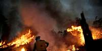 Membro da Brigada de incêndio do Ibama tenta controlar fogo em Apuí, na Amazônia  Foto: Ueslei Marcelino / Reuters