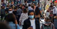 Pessoas com máscaras de proteção caminham em rua movimentada 

REUTERS/Gonzalo Fuentes  Foto: Reuters