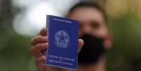 Homem mostra carteira de trabalho enquanto procura por vagas de emprego no centro de São Paulo
06/10/2020
REUTERS/Amanda Perobelli  Foto: Reuters