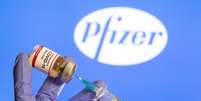 Mulher segura frasco rotulado como de vacina contra Covid-19 em frente a logo da Pfizer em foto de ilustração
30/10/2020 REUTERS/Dado Ruvic  Foto: Reuters