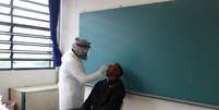 Enfermeira mostra em estudante como é feito teste do coronavírus, em Taboão da Serra (SP)
15/10/2020
REUTERS/Amanda Perobelli  Foto: Reuters