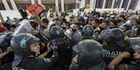 Policiais tentam dispersar os torcedores (Foto: JUAN MABROMATA / AFP)  Foto: LANCE!