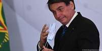 Bolsonaro retira a máscara após pronunciamento: presidente deu série de declarações polêmicas durante a pandemia  Foto: DW / Deutsche Welle