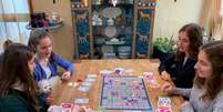 Rebecca, Lara, Stella e Sarah Schwaderlapp jogam jogo de tabuleiro sobre o coronav&iacute;rus que inventaram durante confinamento na Alemanha
20/12/2020 REUTERS/Annkathrin Weiss  Foto: Reuters