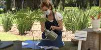 Ana Furtado rega muda de flamboyant que plantou em homenagem a Nicette Bruno.  Foto: Reprodu&ccedil;&atilde;o '&Eacute; de Casa' / Globo (2020) / Estad&atilde;o