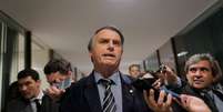 Em foto de setembro de 2018, Bolsonaro fala com a imprensa em corredor do Congresso; ele foi eleito com agenda 'antipolítica'  Foto: REUTERS/Adriano Machado / BBC News Brasil