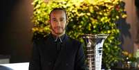 Hamilton com o trof&eacute;u do Mundial de Construtores, ops, de Pilotos.  Foto: Divulga&ccedil;&atilde;o