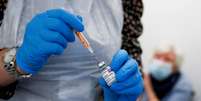 Um profissional de saúde enche uma seringa com uma dose da vacina Oxford / AstraZeneca COVID-19  Foto: Jason Cairnduff / Reuters