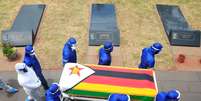 Pessoas com trajes de proteção carregam caixão em enterro de dois ministros e um general aposentado que morreram de Covid-19 no Zimbábue
29/01/2021 REUTERS/Philimon Bulawayo  Foto: Reuters
