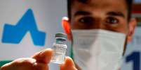 trabalhador da saúde segurando vacina  Foto: Getty Images / BBC News Brasil