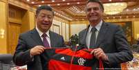 Bolsonaro presenteia casaco do Flamengo ao presidente da China, Xi Jinping, em outubro de 2019  Foto: DW / Deutsche Welle